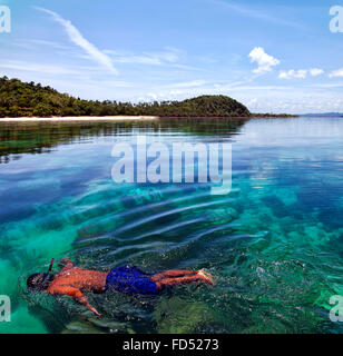 Junge männliche Schnorchler schwimmt auf einem Korallenriff der Insel in Thailand. Stockfoto