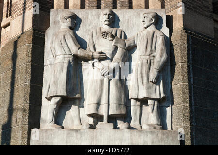 Steinstatue / Statuen / Arbeiter Kunstfries außen vor dem Stadtarchiv / Archiv; Stadsarchief Art déco-Gebäude (DeBazel) Amsterdam. Holland. Niederlande. Stockfoto