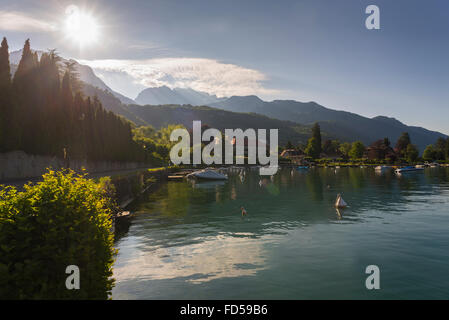 Morgensonne über dem Hafen von Talloires am Lac d ' Annecy vor der Dents de Lanfon und Lanfonnet Berge in Savoie, Frankreich Stockfoto