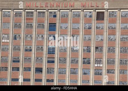 Millennium Mills Royal Victoria Dock Silvertown London Blume Mühle verfallenen zertrümmerte Fenster Blau Himmel Sanierung blauen Tore Stockfoto