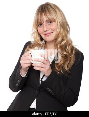 Schöne stilvolle Frau in eine maßgeschneiderte schwarze Jacke, genießen eine Tasse Kaffee mit einem freundlichen Lächeln in die Kamera schaut Stockfoto