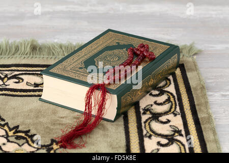 Koran-Buch und die Gebetskette auf einem Teppich Stockfoto