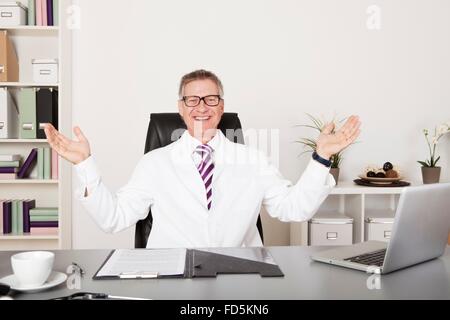 Glücklich männlich Medical Doctor Looking at Kamera verbreiten seine Arme Stockfoto