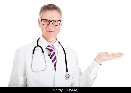 Mittleren Alters männlichen Arzt in Gläsern, seine leere Handfläche hochhalten über weiße Exemplar für Ihr Product-placement Stockfoto