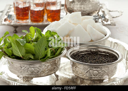 Marokkanischer Tee-Set mit Zucker, Minze und Tee in traditionellen Schalen Stockfoto