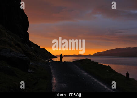 Angler Silhouette gegen den Winter Sonnenuntergang an den Gribun Felsen auf der Isle of Mull, Schottland Stockfoto