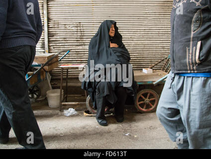 alte Frau sitzen auf einer Bank auf dem Basar, Central District, Teheran, Iran Stockfoto