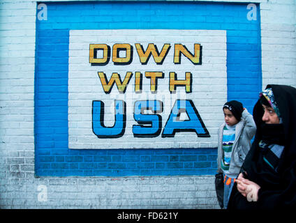 Passanten vor Wandbild Anti-amerikanische Propaganda an der Wand des ehemaligen US-Botschaft, Central District, Teheran, Iran Stockfoto