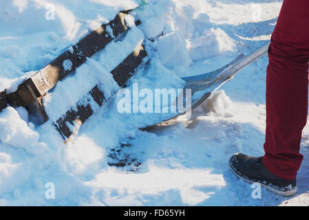 Mann Schaufeln Schnee hautnah. Mann Reinigung Schnee vom Gehsteig vor Haus. Stockfoto