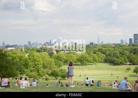 Primel-Hügel mit Blick auf die Stadt London und Menschen entspannen im Park, junge Frau nimmt Bilder Stockfoto