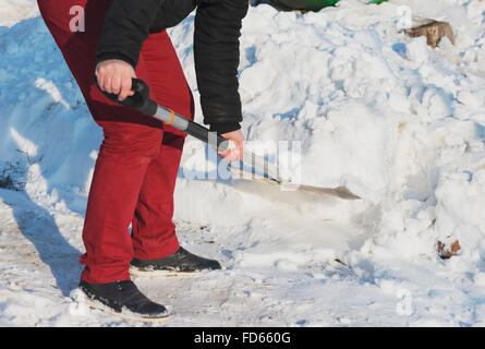 Mann Schaufeln Schnee hautnah. Mann Reinigung Schnee vom Gehsteig vor Haus. Stockfoto