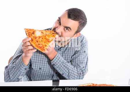 Junger Mann beißt ein Stück vegetarische pizza Stockfoto