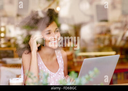 Frau am Telefon Lächeln während Sie in einem Café Stockfoto