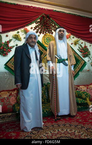 Bräutigam, posiert mit seinem Vater in seinem neuen Tracht während einer Hochzeitszeremonie, Hormozgan, Bandar-e Kong, Iran Stockfoto