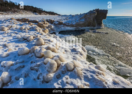 Eiskugeln in der Brandung, dann gefrorene Solid als Teil des Eises See am Rande des Lake Michigan in rosigen Hügel natürlichen Umgebung ausgebildet, Stockfoto