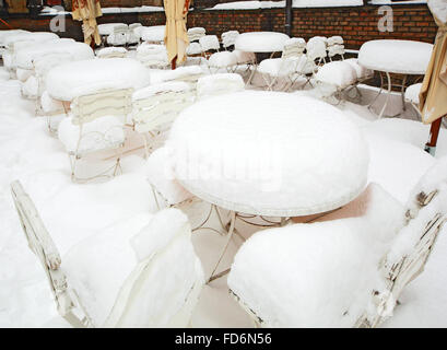 Schnee-bedeckten Tische und Stühle vor dem restaurant Stockfoto