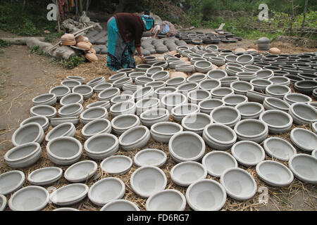 Dhaka, Bangladesch, 28. Januar 2016. Bethee, 28, ist Ton-Töpfe halten in der Sonne zum Trocknen von Kumar RN (Töpfer-Gemeinschaft) in Munshigonj Nähe von Dhaka, Bangladesh. Mehr als 100 Familien in der Gemeinde als sie Keramik ist eine der Quellen des Einkommens, aber es hat sich auf die alarmierende Zahl kommen. Der Grund für das Verlassen des Handels ist viele: hohe Kosten für Materialien, die jemals verlieren Wettlauf mit Kunststoff und Aluminium waren, niedrigen Preis und vieles mehr. Die Töpfer der Gegend sagen, dass sie bemüht sind, das uralte Handwerk zu speichern, das seinen Ruhm wegen Mangel an Aufmerksamkeit und Pflege verloren hat. Stockfoto