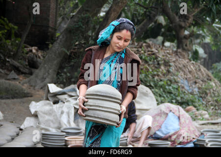 Dhaka, Bangladesch, 28. Januar 2016. Bethee, 28, ist Ton-Töpfe halten in der Sonne zum Trocknen von Kumar RN (Töpfer-Gemeinschaft) in Munshigonj Nähe von Dhaka, Bangladesh. Mehr als 100 Familien in der Gemeinde als sie Keramik ist eine der Quellen des Einkommens, aber es hat sich auf die alarmierende Zahl kommen. Der Grund für das Verlassen des Handels ist viele: hohe Kosten für Materialien, die jemals verlieren Wettlauf mit Kunststoff und Aluminium waren, niedrigen Preis und vieles mehr. Die Töpfer der Gegend sagen, dass sie bemüht sind, das uralte Handwerk zu speichern, das seinen Ruhm wegen Mangel an Aufmerksamkeit und Pflege verloren hat. Stockfoto