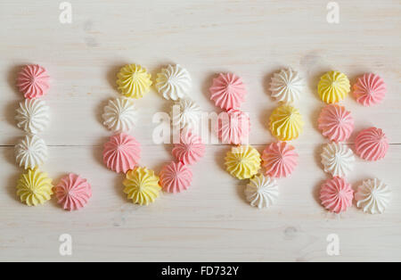 Aufschrift Liebe Baiser gemacht der Pastell-Farben auf weißem Hintergrund aus Holz. Bild der Valentinstag Stockfoto