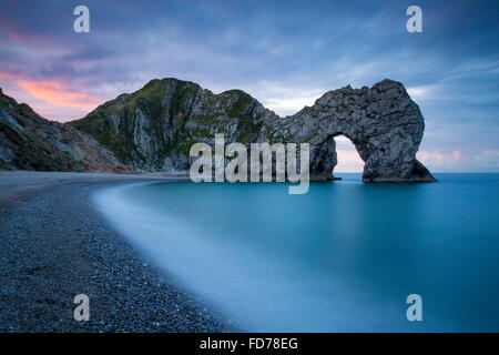 Bunten Himmel im Morgengrauen über Durdle Door entlang der Jurassic Coast, Dorset, England Stockfoto