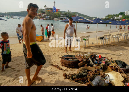 Männer sammeln Müll aus dem Meer am Playa Caleta Beach, Acapulco, Mexiko. Stockfoto