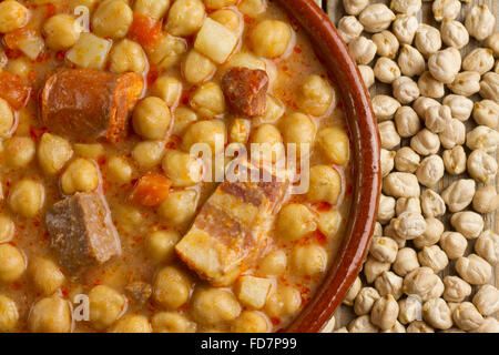 Getrocknete Kichererbsen und spanischen Cocido in einem Tontopf auf einem Holztisch Stockfoto