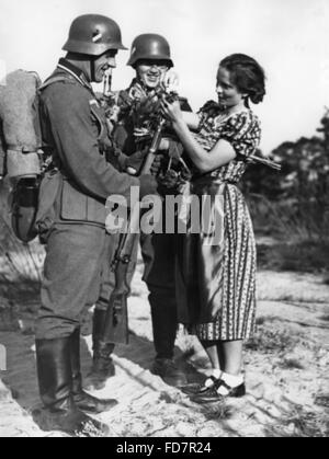 Soldaten der Wehrmacht mit einem Mädchen, 1938 Stockfoto