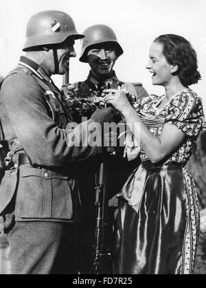 Soldaten der Wehrmacht mit einem Mädchen, 1938 Stockfoto