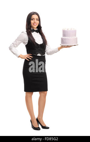 In voller Länge Portrait von eine junge Kellnerin hält einen Kuchen und schaut in die Kamera, die isoliert auf weißem Hintergrund Stockfoto