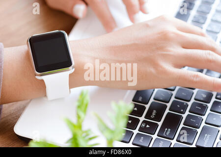 Closeup Hand Uhr mit Laptop am Schreibtisch Stockfoto