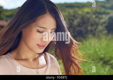 Chinesische junge Schönheit in der Natur mit den Augen Lächeln geschlossen Stockfoto