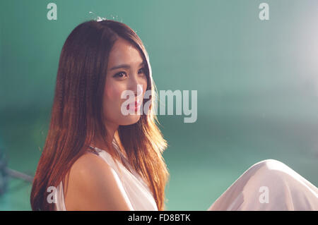 Nahaufnahme einer Schönheit lächelnd mit grünem Hintergrund Stockfoto