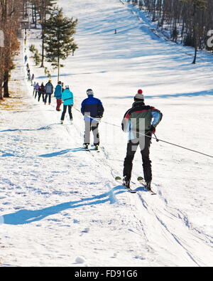 Skifahrer am Skilift bergauf gehen. Natur und Sport Hintergrund. Stockfoto