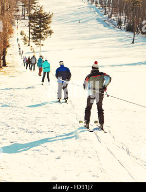 Skifahrer am Skilift bergauf gehen. Natur und Sport Hintergrund. Foto mit Retro-Filter-Effekt. Stockfoto