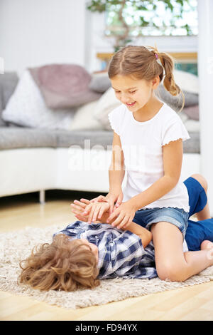 Zwei Kinder spielen und Toben zu Hause im Wohnzimmer Stockfoto