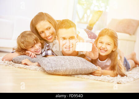 Glückliche Familie mit zwei Kindern unter Smartphone Selfie zu Hause Stockfoto
