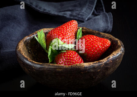 Frische Erdbeeren in braun Keramikschale. Makro, Nahaufnahme. Natürliches Licht, selektiven Fokus Stockfoto