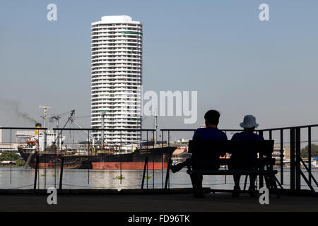 paar auf einer Bank am Wasser sitzen Stockfoto