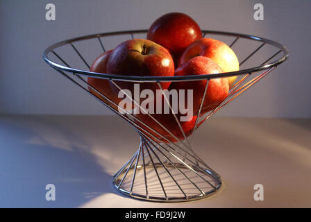 Äpfel auf dem Display in Obst Drahtkäfig Stockfoto