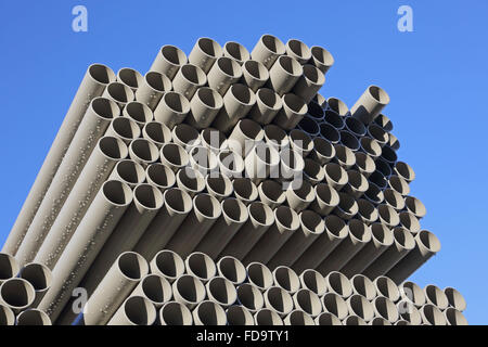 Nahaufnahme von grau, Kunststoff Wasserleitungen gestapelt in einem Outdoor-Hof für die Lagerung und Lieferung. Blauer Himmelshintergrund. Stockfoto