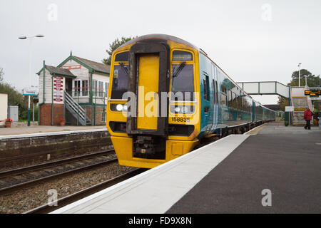 Arriva Züge Wales ATW 158s gebaut von BR bilden die Manchester-Piccadilly, Holyhead Service durch Helsby HSB, Cheshire Stellwerk hinter. Stockfoto