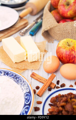 Zutaten für einen Apfelkuchen auf einem rustikalen Tisch. Stockfoto