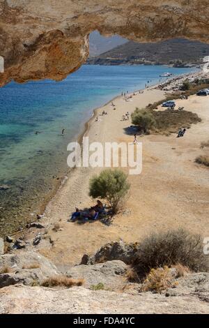 Überblick über Petra Strand aus einer erodierten Tunnel durch einen großen vulkanischen Felsen oberhalb des Strandes, benannt "Kalikatsou", Patmos, Dodecan Stockfoto