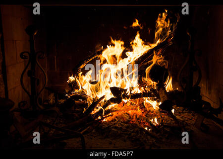 Holz Feuer in einem Kamin mit Flammen brennen, Stämme und Äste Stockfoto