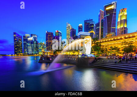 Skyline von Singapur und der Merlion in der Dämmerung. Stockfoto
