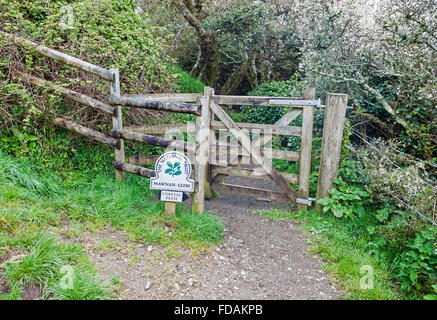 National Trust Omega Schild mit der Aufschrift Mawnan Glebe auf einem Wanderweg und Tor am Cornwall England UK Stockfoto