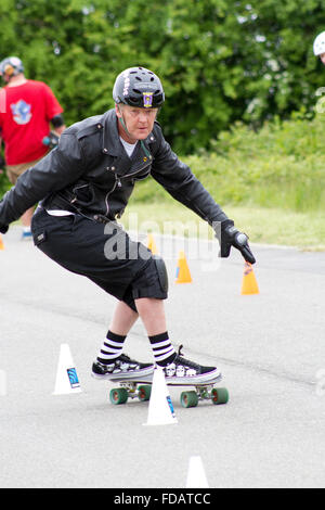 Mann mittleren Alters im Wettbewerb mit einem Skateboard slalom Stockfoto