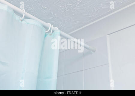 Oben auf einem blauen Duschvorhang hängt an einer Schiene Stockfoto