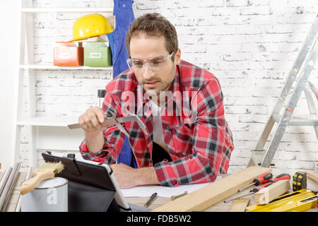 ein junger Zimmermann mit Bremssattel, in seiner Werkstatt Stockfoto