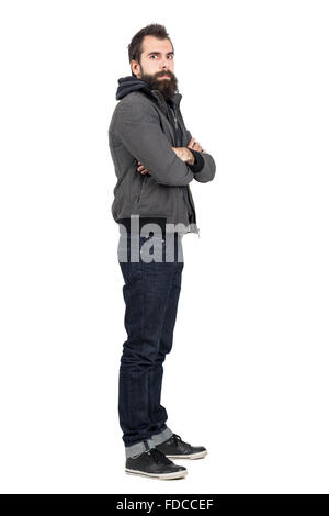 Profil Ansicht des bärtigen Mann mit Jacke über Sweatshirt mit verschränkten Armen Blick in die Kamera. Ganzkörper-Länge-Porträt isoliert Stockfoto